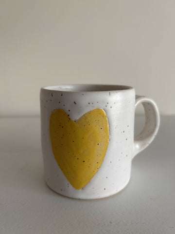 white speckled mug with yellow heart