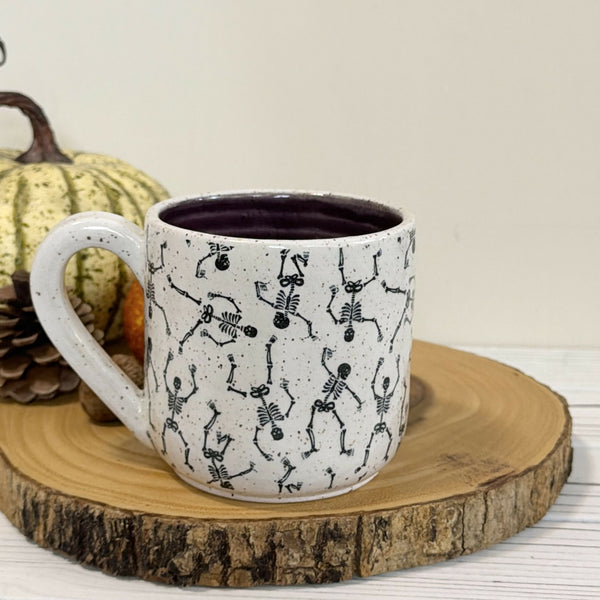 14 oz. Skeleton patterned white speckled mug with dark purple inside