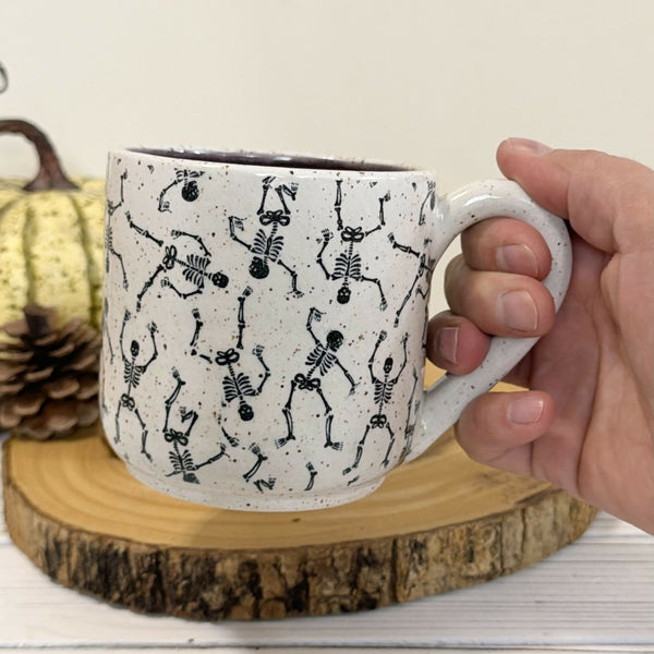 14 oz. Skeleton patterned white speckled mug with dark purple inside