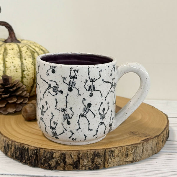 14 oz. Skeleton patterned white speckled mug with dark purple inside